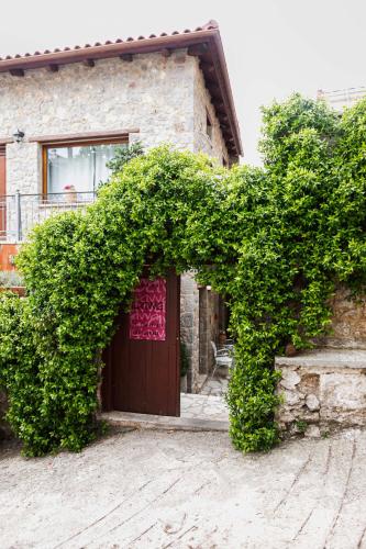 a building with a large green hedge in front of a door at Guest House Ioanna Arachova in Arachova