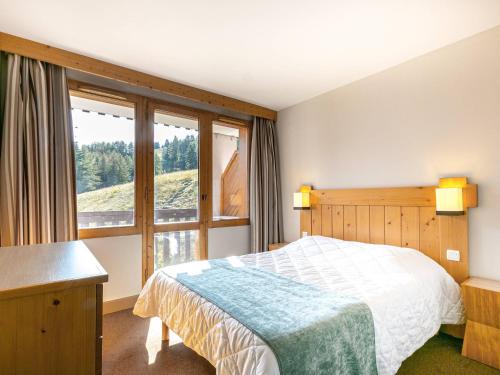 Un dormitorio con una cama y una ventana grande. en Appartement cosy 2 pièces, 5 pers, balcon, La Plagne - FR-1-353-81, en Montchavin