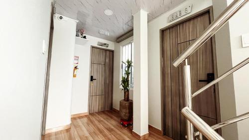 a hallway with two wooden doors and a potted plant at Hospedaje Casa Rueda in Barranquilla