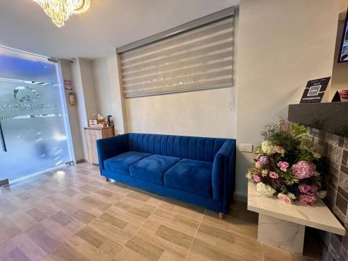 a blue couch in a living room with a window at Hospedaje Casa Rueda in Barranquilla