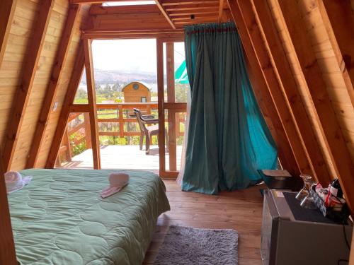 a bedroom with a bed and a large window at El Alpino Cabaña Glamping & Camping in Guatavita