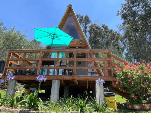 a tree house with a blue umbrella on it at El Alpino Cabaña Glamping & Camping in Guatavita