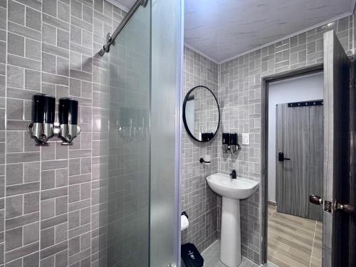 a bathroom with a sink and a shower with a mirror at Hospedaje Casa Rueda in Barranquilla