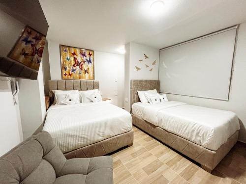 a hotel room with two beds and a couch at Hospedaje Casa Rueda in Barranquilla