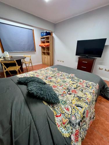 a bedroom with a bed and a flat screen tv at Casa Cavancha in Iquique