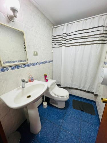 a bathroom with a white sink and a toilet at Casa Cavancha in Iquique