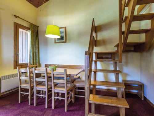 une salle à manger avec une table et des chaises en bois dans l'établissement Duplex cosy 2 chambres, balcon, proche commerces et remontées, accepte animaux - FR-1-356-362, à Valmorel