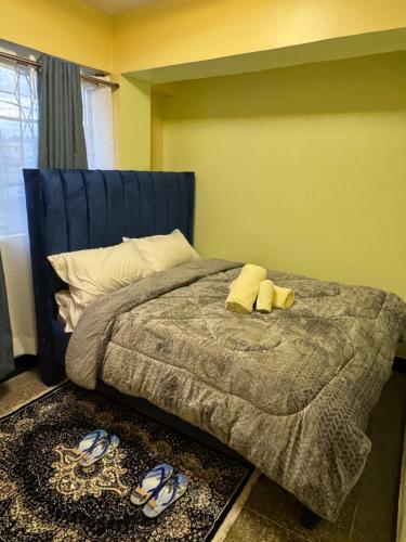 a bedroom with a bed with a blue headboard at One Bedroom Modern Apartment in Nyahururu in Nyahururu