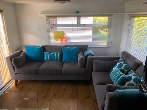 a living room with a gray couch with blue pillows at Jos lakes Escape in Cockermouth
