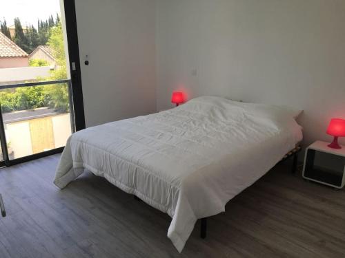 une chambre avec un lit et une grande fenêtre dans l'établissement Villa contemporaine avec piscine, à Villeneuve-lès-Maguelone