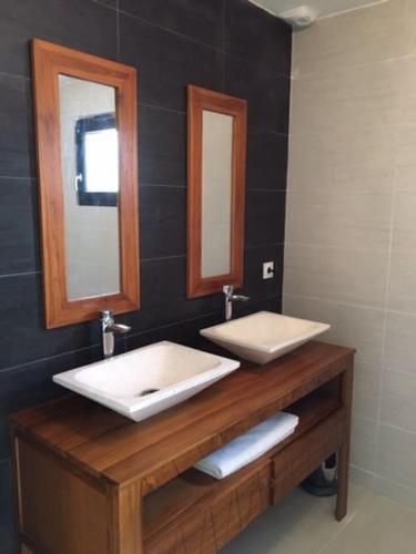 une salle de bain avec deux lavabos et deux miroirs dans l'établissement Villa contemporaine avec piscine, à Villeneuve-lès-Maguelone