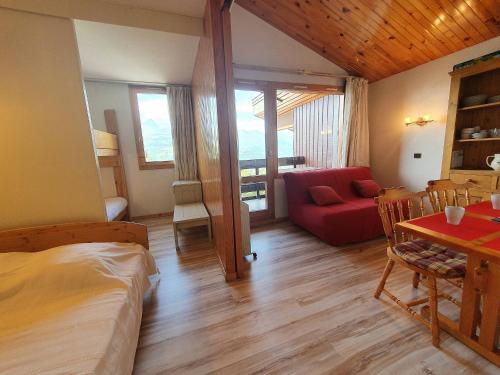 une chambre avec un lit, une table et un canapé dans l'établissement Studio divisible pour 4 personnes, centre station, animaux admis - FR-1-353-103, à La Plagne Tarentaise