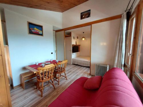 un salon avec un canapé rouge et une table dans l'établissement Studio divisible pour 4 personnes, centre station, animaux admis - FR-1-353-103, à La Plagne Tarentaise