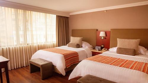 a hotel room with two beds and a window at Bogota Plaza Hotel in Bogotá