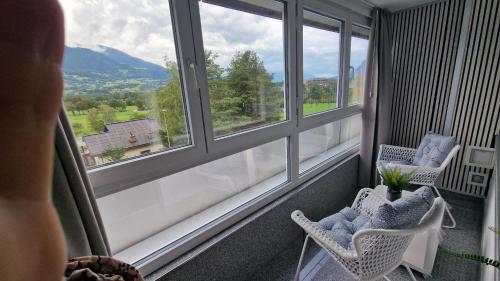 a balcony with two chairs and a view of a mountain at Motel 96 in Balzers