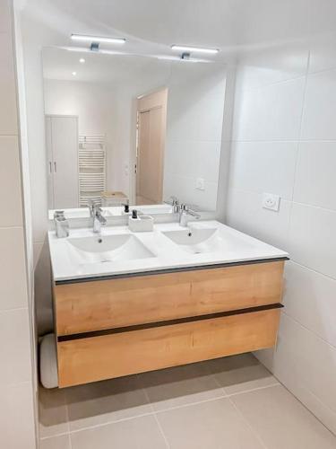 a bathroom with two sinks and a large mirror at Le Repos Chartrain in Chartres