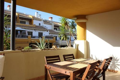 a wooden table and chairs on a balcony at Apartamento Costa de la Luz Golf y Playa in Ayamonte