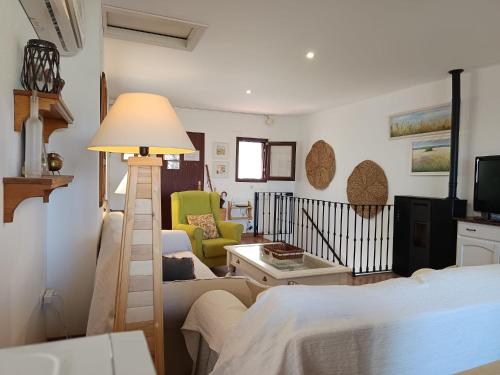 a room with a bed and a lamp and a living room at Casa Rural El Olivo in Aracena