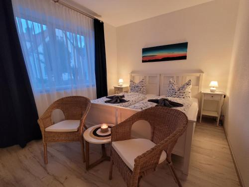 a bedroom with two beds and chairs and a table at Ballenstedt Gartenblick in Ballenstedt