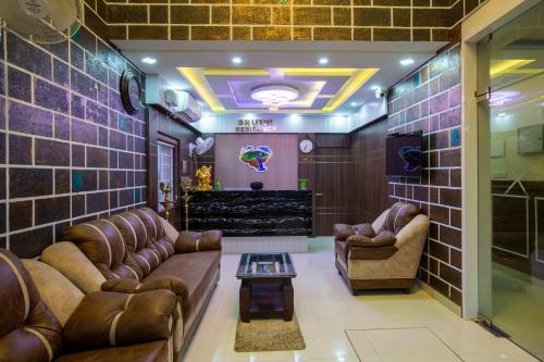 a waiting room with leather couches and a stage at Sruthi Residency in Rāmeswaram