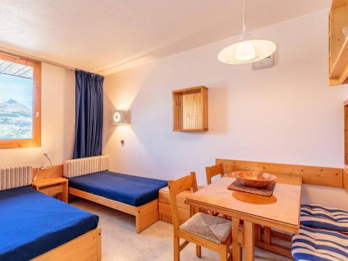 une chambre avec deux lits et une table dans l'établissement Studio confortable à La Plagne - 4 pers, parking, animaux admis - FR-1-353-111, à La Plagne Tarentaise