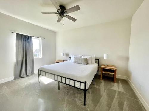 a white bedroom with a bed and a ceiling fan at Papillion The White Pine Modern Spacious with Garage in Papillion