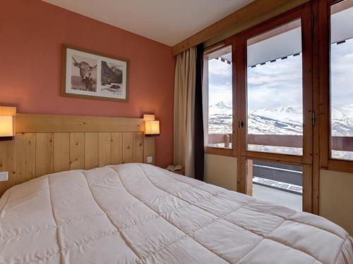 une chambre avec un grand lit et une grande fenêtre dans l'établissement Charmant duplex 8 pers avec balcon, proche pistes et navette à La Plagne - FR-1-353-97, à La Plagne Tarentaise