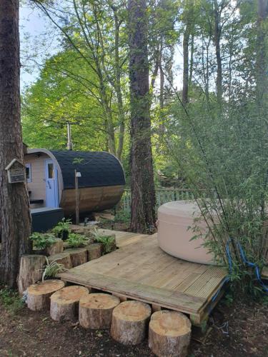 une terrasse en bois avec un bateau et une remorque dans l'établissement Cabane dans les arbres, à Beaumontel