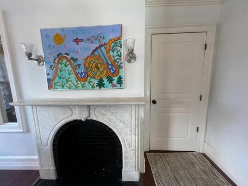 a painting sitting on top of a fireplace at C&J Signature Stays Downtown Apartment in Morristown