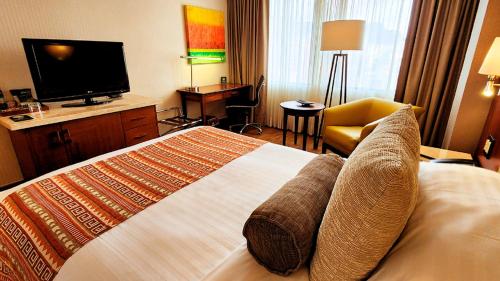 a hotel room with a bed and a television at Bogota Plaza Hotel in Bogotá