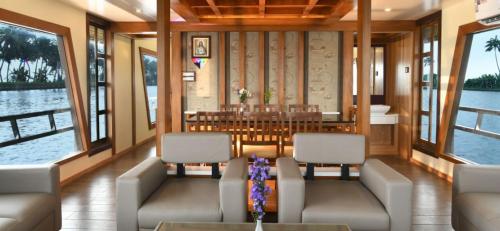 a dining room on a boat with chairs and a table at Venezia Houseboats in Alleppey