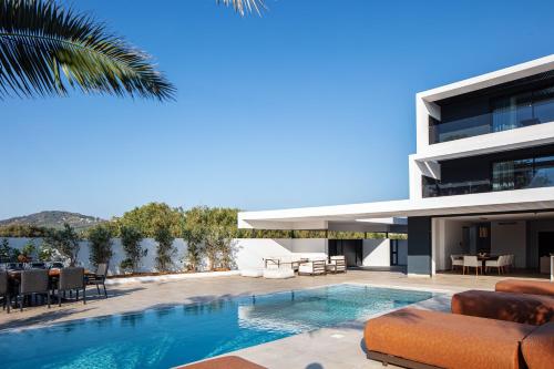 a house with a swimming pool next to a building at Nuera Villas in Chania