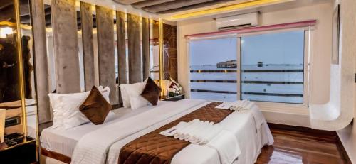 a bedroom with a large bed with a large window at Venezia Houseboats in Alleppey