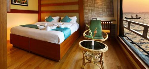 a bedroom with a large bed and a balcony at Venezia Houseboats in Alleppey