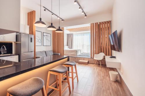 a kitchen and living room with a counter and stools at Probar Suites Punta Cana in Punta Cana