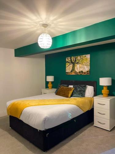 a bedroom with a large bed with a green wall at Redcar - Seafront, 6 Bedrooms, Short Stays in Redcar