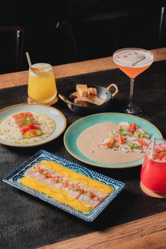 a table with plates of food and a drink at Probar Suites Punta Cana in Punta Cana
