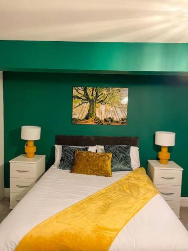 a green bedroom with a bed and two lamps at Redcar - Seafront, 6 Bedrooms, Short Stays in Redcar