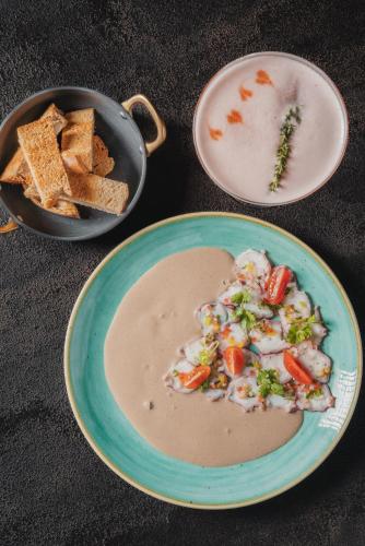 a plate of food with a bowl of soup and bread at Probar Suites Punta Cana in Punta Cana