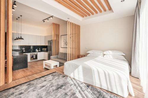 a bedroom with a white bed and a kitchen at Probar Suites Punta Cana in Punta Cana