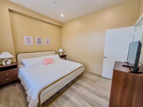 a bedroom with a bed and a flat screen tv at Peach Street Inn by WanderLodges in Medford