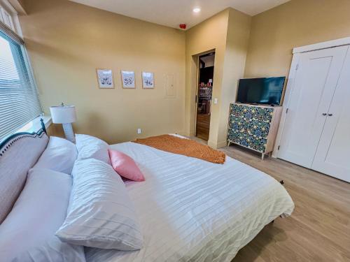 a bedroom with a bed with pillows and a television at Peach Street Inn by WanderLodges in Medford