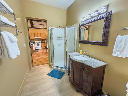 a bathroom with a shower and a sink and a mirror at Peach Street Inn by WanderLodges in Medford
