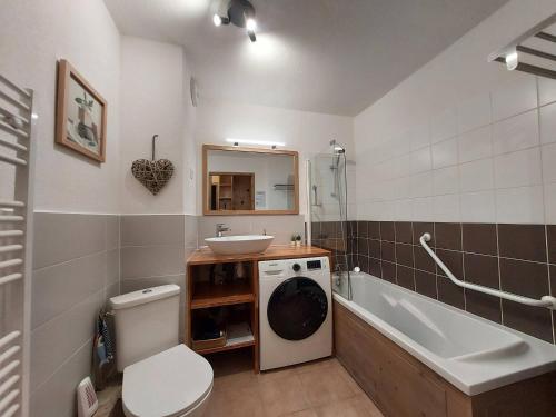 une salle de bain avec toilettes et lavabo et une machine à laver dans l'établissement Appartement cosy 3 pièces, avec balcon et piscine, proche des pistes et commodités à La Plagne Tarentaise - FR-1-353-118, à La Plagne Tarentaise