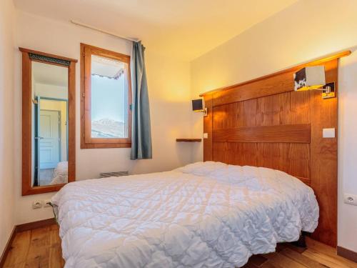 une chambre avec un grand lit et un miroir dans l'établissement Appartement cosy 4 pers avec balcon, départ skis aux pieds, ascenseur, La Plagne-Tarentaise - FR-1-353-121, à La Plagne Tarentaise