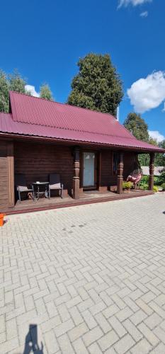 a building with a table and benches in front of it at Sodyba "Kristina" in Biržai