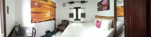 a bedroom with a bed and a painting on the wall at BRICK VILLA in Ahangama