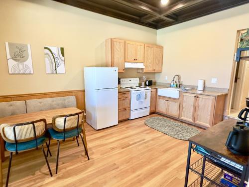 a kitchen with a white refrigerator and a table and chairs at Peach Street Inn by WanderLodges in Medford