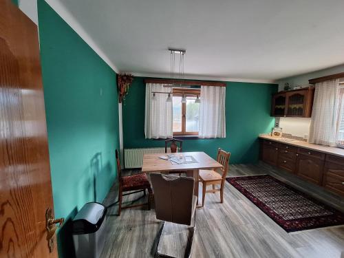 a dining room with green walls and a table and chairs at Ganzes Haus mit Almcharakter in Lieserbrücke