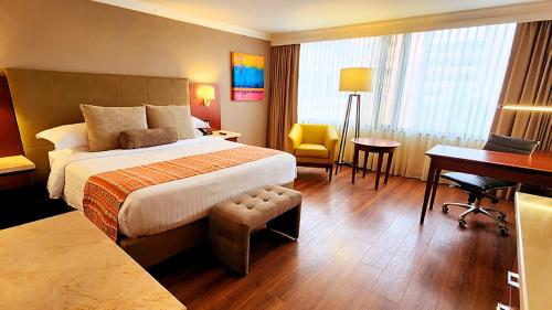 a hotel room with a bed and a desk at Bogota Plaza Hotel in Bogotá